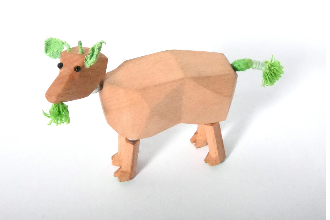 Wooden goat with green horns and tail