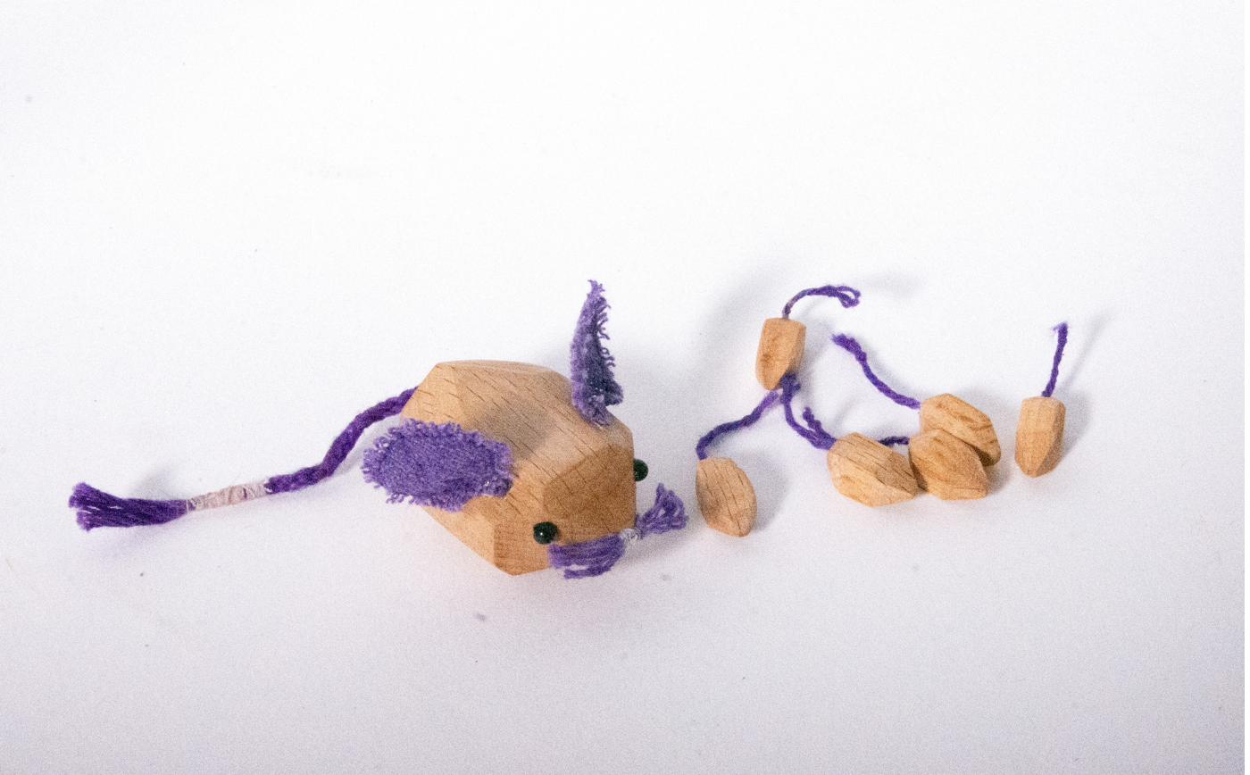 Wooden mouse with purple yarn details and small loose parts
