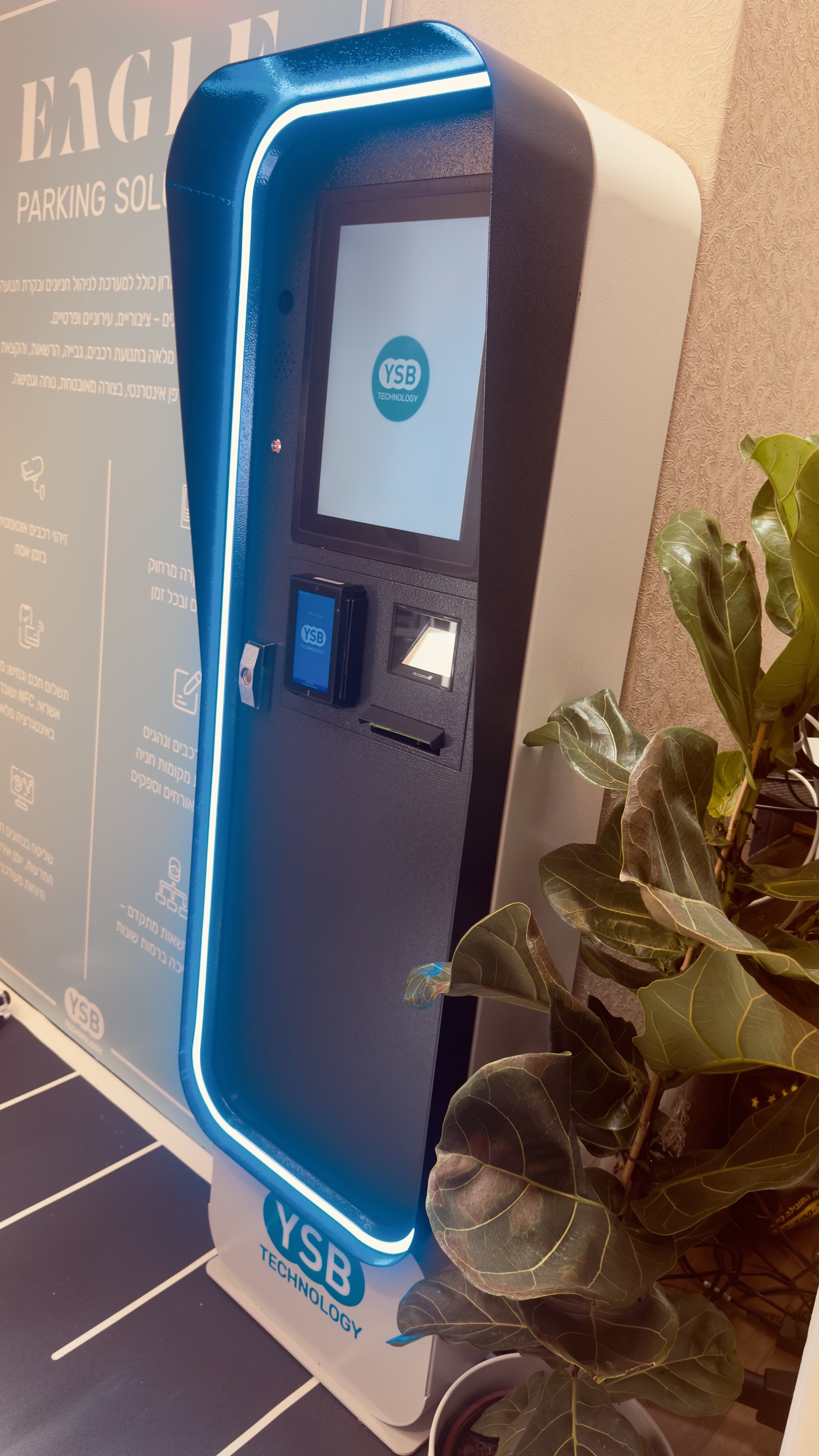 Close-up of the EAGLE self-service parking terminal with glowing trim, touchscreen, and contactless reader
